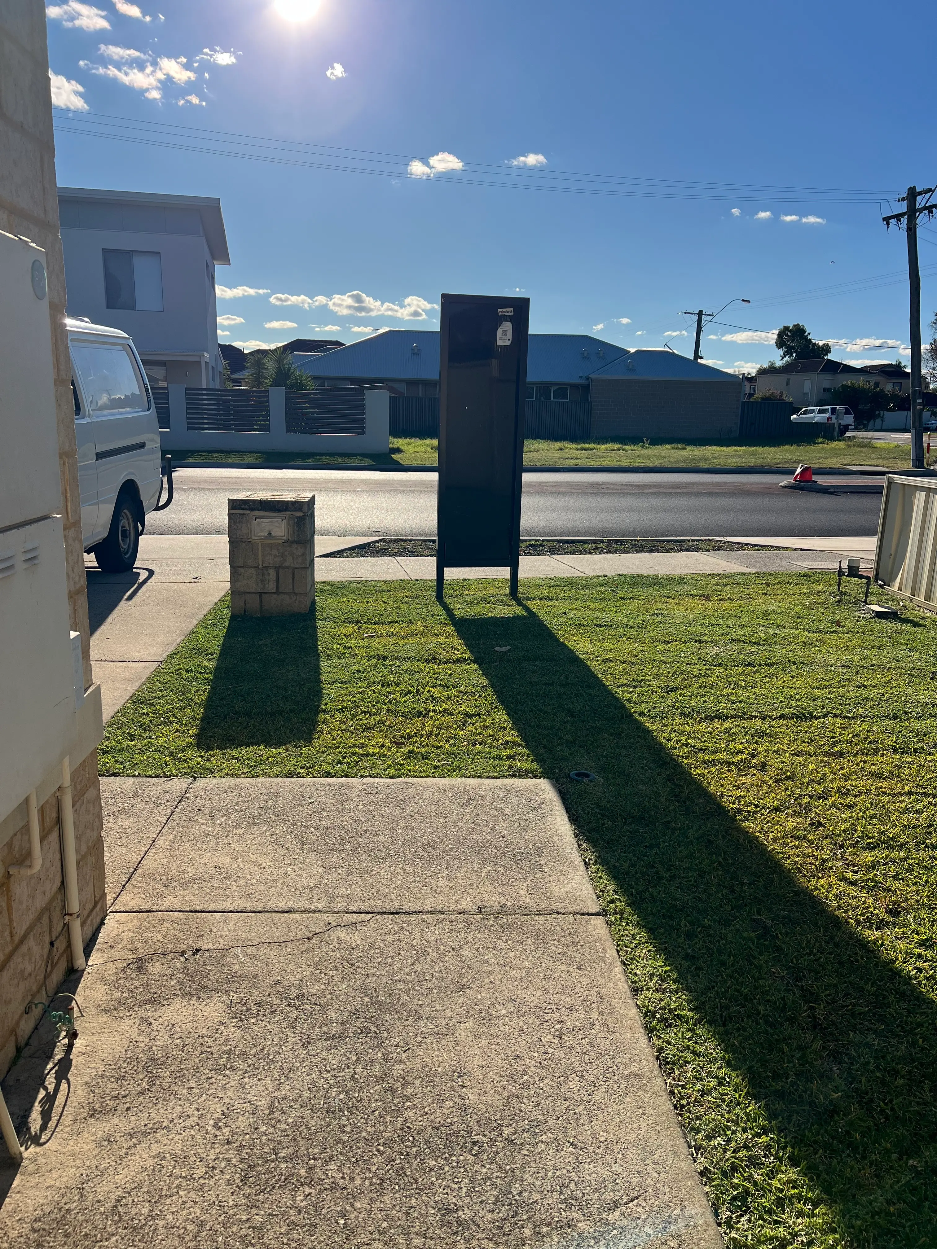 Mown grass verge and concrete path outside a street-facing property